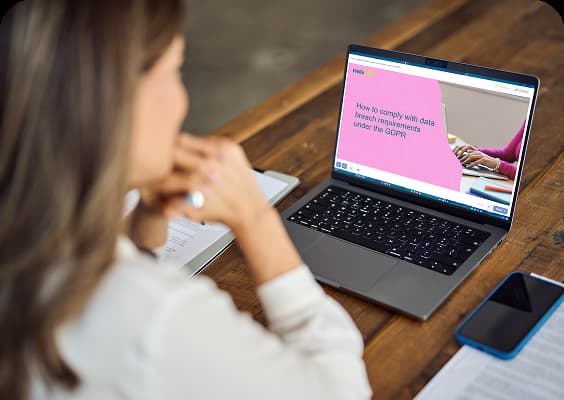 Woman looking at a laptop showing a blog post from HelloDPO's website